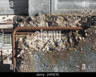 béton armé endommagé avec barres de résistance en acier rouillé exposées arrière-plan industriel Banque D'Images