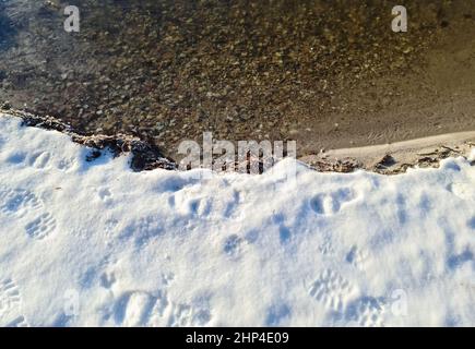 Vue sur le lac gelé avec reflet du ciel bleu par temps clair Banque D'Images