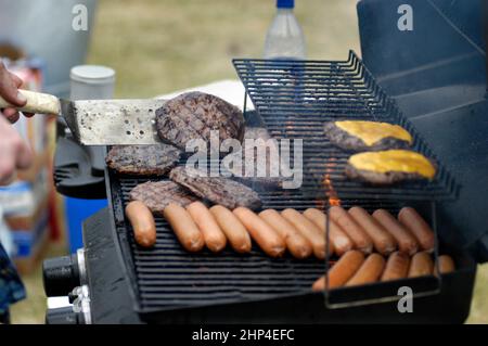 Hamburgers et hot-dogs cuisant sur le Bar-B-Q au Club Cookout pour les enfants et les familles Banque D'Images