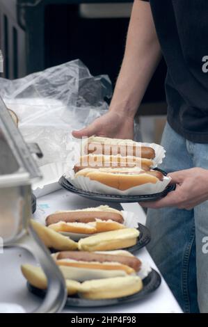 Hamburgers et hot-dogs cuisant sur le Bar-B-Q au Club Cookout pour les enfants et les familles Banque D'Images