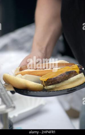 Hamburgers et hot-dogs cuisant sur le Bar-B-Q au Club Cookout pour les enfants et les familles Banque D'Images