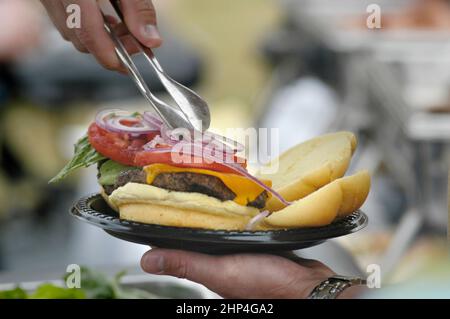 Hamburgers et hot-dogs cuisant sur le Bar-B-Q au Club Cookout pour les enfants et les familles Banque D'Images