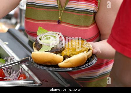 Hamburgers et hot-dogs cuisant sur le Bar-B-Q au Club Cookout pour les enfants et les familles Banque D'Images