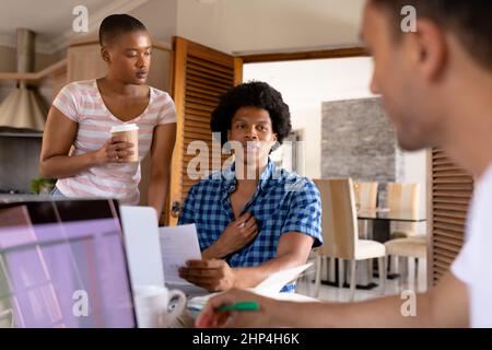 Une jeune équipe de collègues d'affaires multiraciaux discutant tout en travaillant ensemble au bureau à domicile Banque D'Images