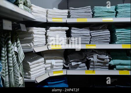 Pile de serviette de bain sur le support des étagères avec étiquette de prix en magasin. Salle de bains en tissu Banque D'Images