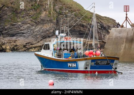 PORT ISAAC, CORNWALL, Royaume-Uni - AOÛT 13 : bateau de pêche à Port Isaac, Cornwall, le 13 août 2013. Trois personnes non identifiées Banque D'Images