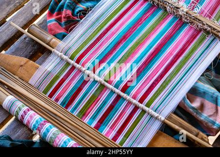 Une image de gros plan de fils colorés de tissage traditionnel par le peuple Karen sur un métier à tisser en bois Banque D'Images