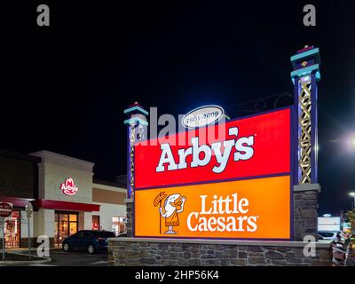 Orlando, Floride - 4 février 2022 : vue de nuit en gros plan sur le panneau d'affichage Arby's and Little Caesars dans le parc forestier et le bâtiment Arby's en arrière-plan Banque D'Images