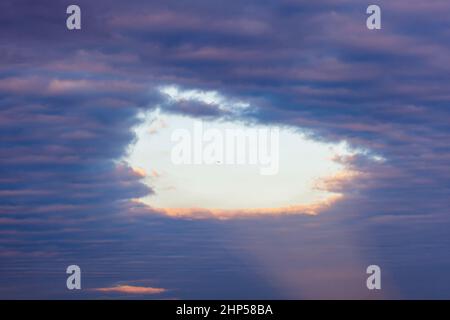 Hélicoptère contre trou dans les nuages bleu foncé, paysage étonnant Banque D'Images