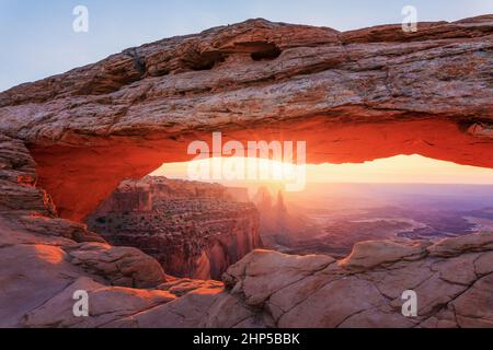 Lever de soleil brumeux au parc national de Mesa Arch Canyonlands, Utah, États-Unis Banque D'Images
