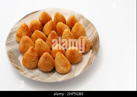 Un hors-d'œuvre brésilien typique appelé Coxinha de Frango isolé sur fond blanc - espace copie. Banque D'Images