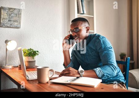 Conclure la vente par téléphone. Photo courte d'un beau jeune homme d'affaires assis seul dans son bureau et parlant sur son téléphone portable. Banque D'Images