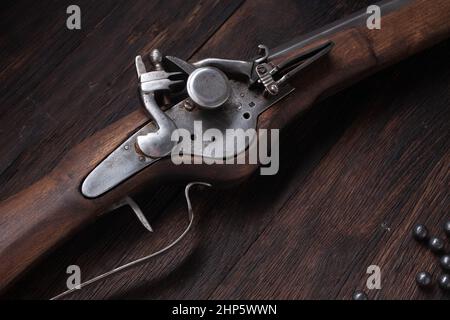 ancienne mousquet de flintlock du xviie siècle avec ballon de poudre et balles led sur terrasse en bois. Banque D'Images