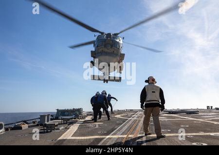 OCÉAN ATLANTIQUE (fév 16, 2022) le compagnon du chef Boatswain, Frank Jimenezmedina, à droite, observe comme des marins à bord du destroyer à missiles guidés de la classe Arleigh Burke USS Roosevelt (DDG 80) accrocher un câble jusqu’à un hélicoptère MH-60R Seahawk, attaché au SquadronHSM (HSM) 79 de l’hélicoptère, 16 février 2022. Roosevelt, déployé vers l'avant à Rota, en Espagne, est en troisième patrouille dans la zone de la Sixième flotte des États-Unis pour soutenir les alliés et les partenaires régionaux et les intérêts de sécurité nationale des États-Unis en Europe et en Afrique. (É.-U. Navy photo by Mass communication Specialist 2nd Class Andrea Rumple/Released) Banque D'Images