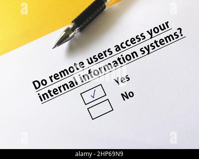 Une personne répond à une question sur la cybersécurité. La personne pense que les utilisateurs distants accèdent à ses systèmes d'information internes. Banque D'Images