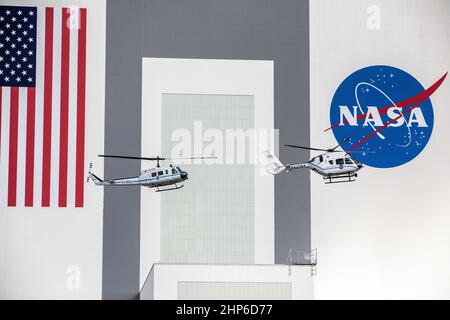 Le 27 octobre 2020, devant l'emblématique bâtiment d'assemblage de véhicules du Kennedy Space Center de la NASA, les hélicoptères Bell Huey 2 (à gauche) et Airbus H135 utilisés pour les opérations de sécurité dans le port spatial de Floride effectuent un vol ensemble avant que les Hueys ne soient retirés de leur service Banque D'Images