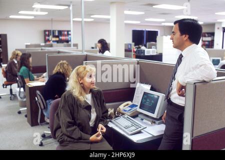 Plusieurs femmes assis et travaillant dans des cabines. Le Service de commande de publications (POS) prend les demandes de publications produites par le National cancer Institute National cancer Institute ca. Septembre 1988 Banque D'Images