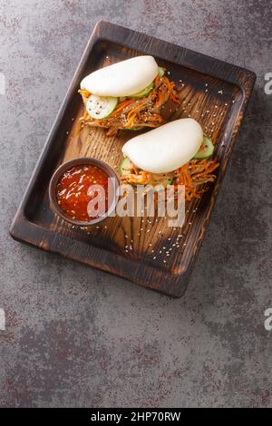 Petits pains Bao cuits au porc et aux légumes dans le tableau de la table. Vue verticale du dessus Banque D'Images