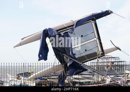 Un catamaran s'est lavé le long du front de mer à Brighton, dans le Sussex, après que Storm Eunice ait causé des dégâts, des perturbations et des rafales de vent record au Royaume-Uni et en Irlande, entraînant la mort d'au moins quatre personnes. Date de la photo: Samedi 19 février 2022. Banque D'Images