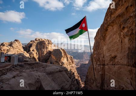 Drapeau noir, blanc, vert et rouge de la Jordanie survolant la destination touristique de Pétra Banque D'Images
