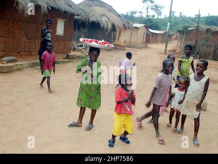 Enfants au Ghana à Village.plateau de transport pour enfants sur la tête. Afrique de l'Ouest Banque D'Images