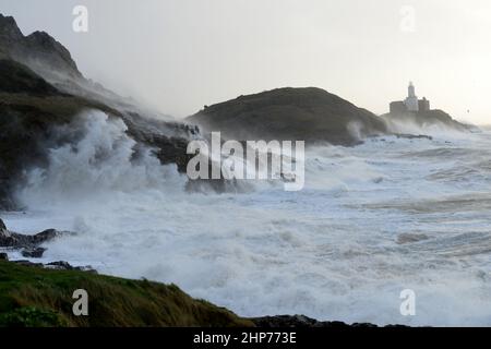 Storm Eunice aux Mumbles. Swansea, pays de Galles, Royaume-Uni. Les vagues engloutissent la falaise et le promontoire pendant que 90mph vents soufflent le jet autour du phare Banque D'Images