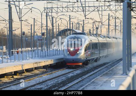 RÉGION DE LENINGRAD, RUSSIE - 21 DÉCEMBRE 20212 : le train à grande vitesse EVS1-13 'Sapsan' passe par la gare de banlieue le matin glacial de décembre Banque D'Images