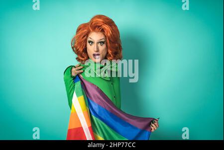 Drag queen célébrant la fierté gay tenant le drapeau arc-en-ciel - concept de communauté sociale LGBTQ Banque D'Images