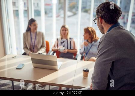 Un jeune homme d'affaires profite d'une pause café avec ses collègues féminins dans une commission lors d'une interview pour un nouveau poste dans un cadre détendu à Banque D'Images
