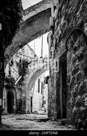 Ancienne rue avec contrefort dans la vieille ville de Jérusalem, Israël. Photographie urbaine en noir et blanc Banque D'Images