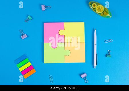 Notes autocollantes vierges sous forme de puzzle sur fond bleu, espace pour le texte Banque D'Images
