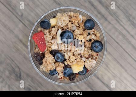 Vue en hauteur du repas complet contenu dans cette tasse de yaourt, bleuets, fraises, et granola pour beaucoup de protéines et de glucides à manger. Banque D'Images