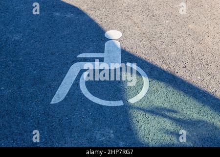 Pictogramme peint sur la route - indique une place de stationnement pour les personnes handicapées. Banque D'Images
