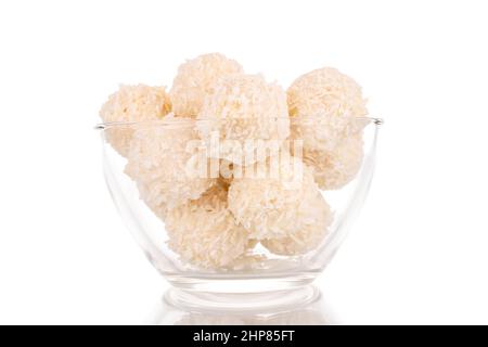 Quelques sucreries de noix de coco sucrées en verre, macro, isolées sur fond blanc. Banque D'Images