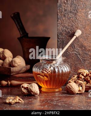 Miel et noix sur une table de cuisine ancienne. Banque D'Images