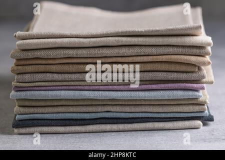 Un tas de quatre tissus en lin naturel aux couleurs ternes et pliés et respectueux de l'environnement sur un fond rustique Banque D'Images