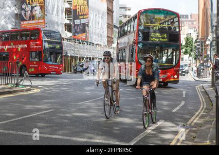 Londres, Royaume-Uni - 20 septembre 2021, Une femme et un homme se promo à vélo sur la route entre les voitures Banque D'Images