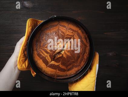 Tarte fraîche et savoureuse dans les mains sur fond de bois. Pose à plat. Banque D'Images