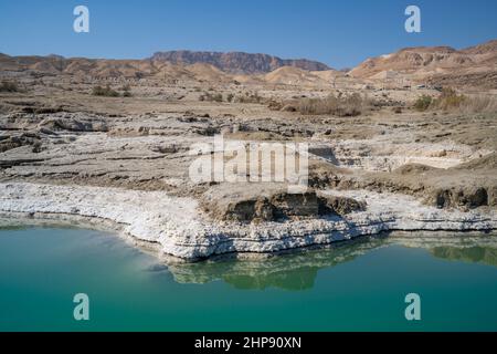 Sédiments de sel reflétés dans l'eau sur la rive de la mer morte, Israël. Banque D'Images