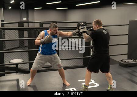 RUSSIE, MOSCOU - 14 FÉVR. 2022: Boxe entraînement gym jeunes gants, de fitness boxer en athlète de solide homme, beau fond. Vêtements de sport Banque D'Images