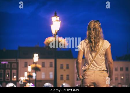 Une femme élégante profite de la vie nocturne dans la ville européenne. Belle jeune femme debout dans la rue dans la ville de nuit Banque D'Images