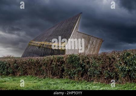 des écuries en bois soufflaient sur son côté de forts vents d'une tempête, orage orage ciel nuageux sombre Banque D'Images