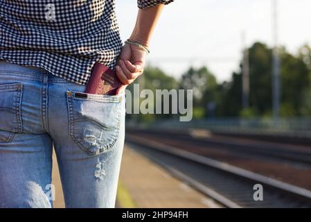 Une femme touristique met son passeport dans la poche et attend le train inter-état. Concept de voyage Banque D'Images