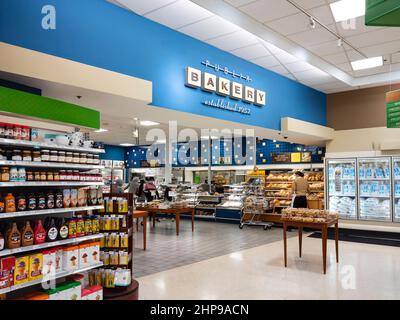 Orlando, Floride - 8 février 2022 : vue intérieure horizontale de la boulangerie Publix avec un préposé au magasin pour empiler le pain. Banque D'Images