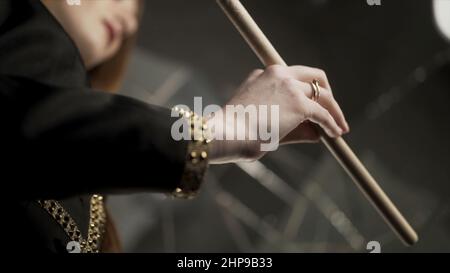 Jeune femme attrayante main tenant le pilon et le tournant pendant la répétition musicale. Gros plan pour femme main avec manucure et anneaux dorés tenant un Banque D'Images