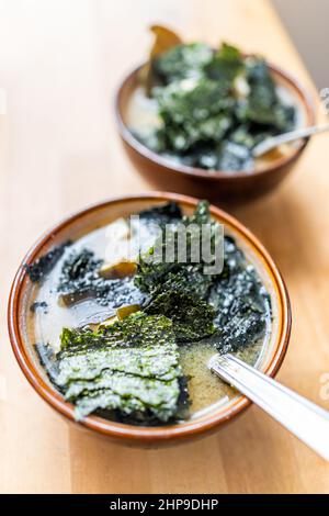 Vue ci-dessus gros plan de la soupe miso deux bols avec algues nori et tofu de soja dans le bouillon comme repas asiatique japonais sur une table en bois Banque D'Images