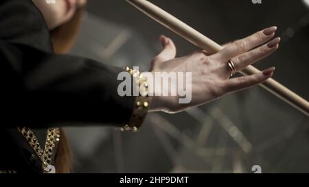 Jeune femme attrayante main tenant le pilon et le tournant pendant la répétition musicale. Gros plan pour femme main avec manucure et anneaux dorés tenant un Banque D'Images