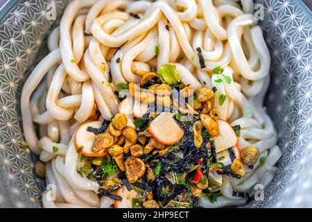 Macro gros plan plat au-dessus de la vue de l'udon ramen japonais soupe instantanée dans le bol comme repas asiatique avec texture de la garniture sèche paquet de sauce Banque D'Images