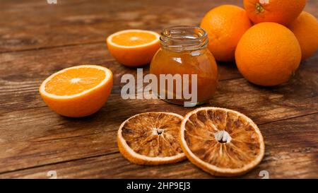 Pot de confiture d'orange, sécher les oranges sur fond de bois depuis la vue de dessus. Marmelade d'orange maison, confiture au sirop épais. Banque D'Images