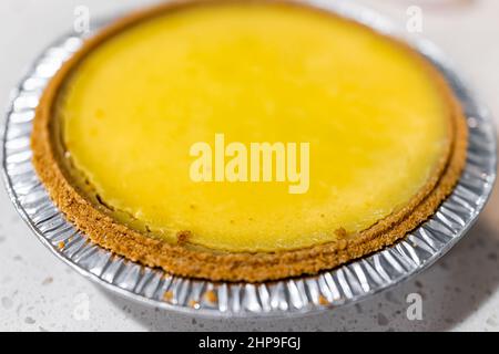 Macro gros plan d'un gâteau entier à tarte au citron vert dans un bac en aluminium contenant sur une table stockeacheté congelé du magasin dans le style traditionnel de Key West avec yell Banque D'Images